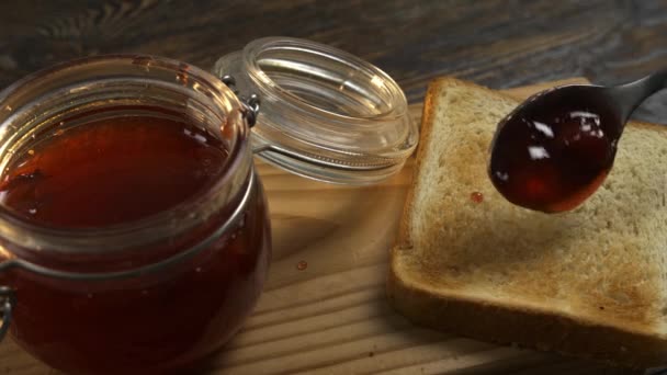 Spreading of strawberry jam on toasted bread - Footage, Video