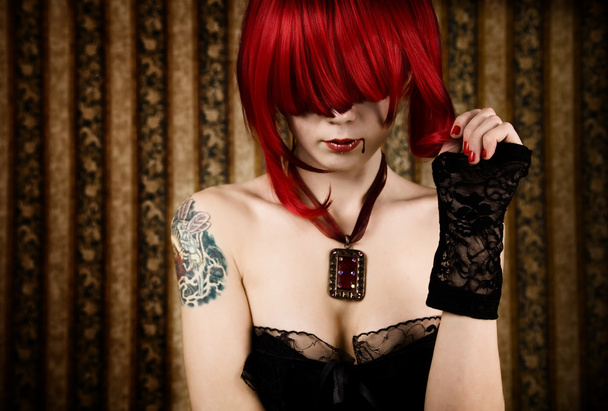 Redhead vampire with drop of blood - Фото, изображение