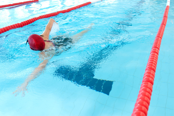 Young woman swim on indoor pool. freestyle mode. - Photo, Image