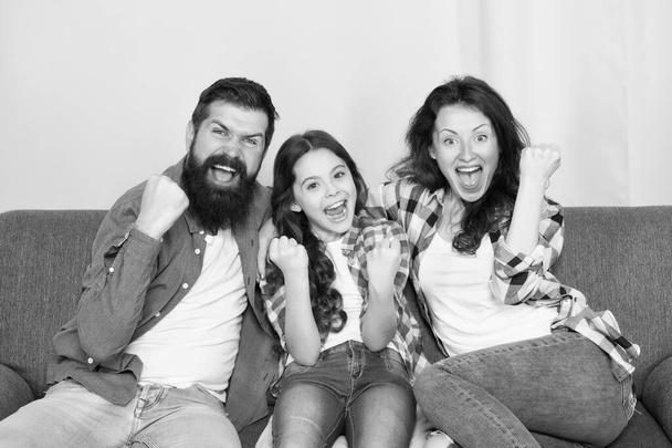 Togetherness is our power. Weekend finally. Little girl relaxing with parents. Stay at home. Family sit on couch. Happy father mother and daughter. Quarantine and isolation concept. Smiling family - Фото, изображение