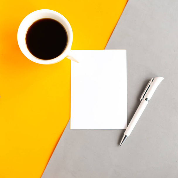 Coffee cup and white mockup blank on geometric grey and orange background, top view. Minimal concept - Фото, зображення