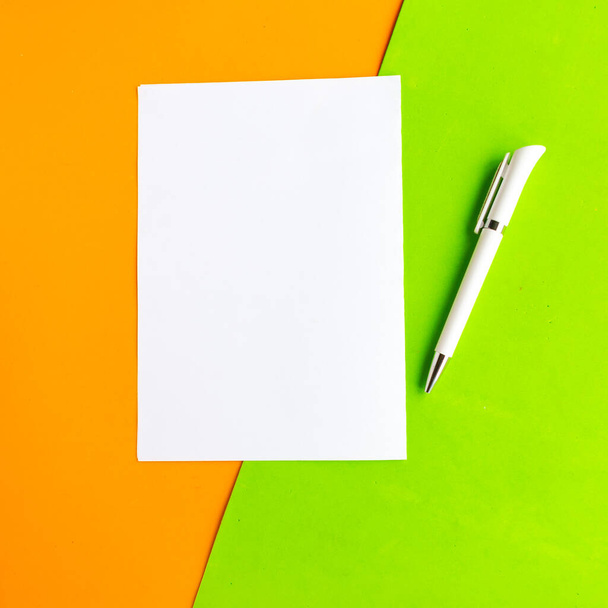 blanco maqueta en blanco sobre fondo geométrico verde y naranja, vista superior. Concepto mínimo - Foto, imagen