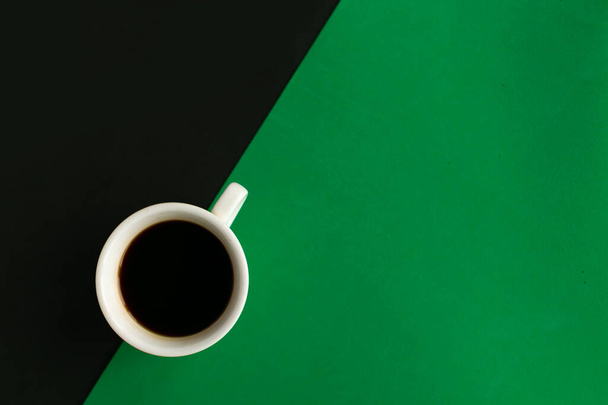 Coffee cup on geometric black and green background, top view, copy space for the text, minimal concept - Φωτογραφία, εικόνα
