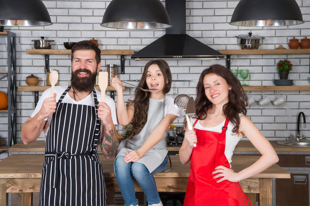 Parents mom dad and daughter cooking food together, family time concept - Photo, Image