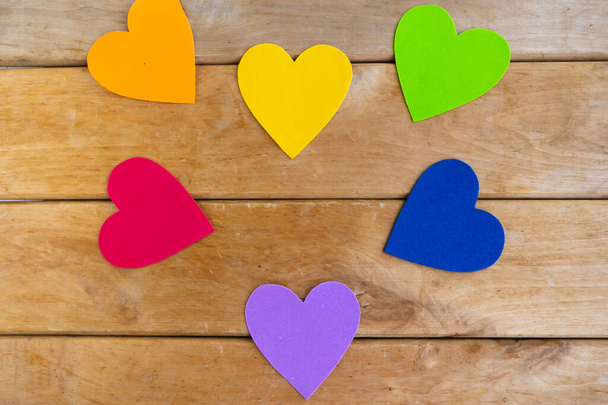 Hearts in lgbtq colors on wooden background, top view, copy space - Foto, Imagem