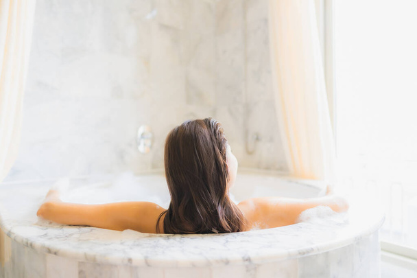 Muotokuva kaunis nuori aasialainen nainen rentoutua kylpy kylpyammeessa kylpyhuoneessa sisustus - Valokuva, kuva