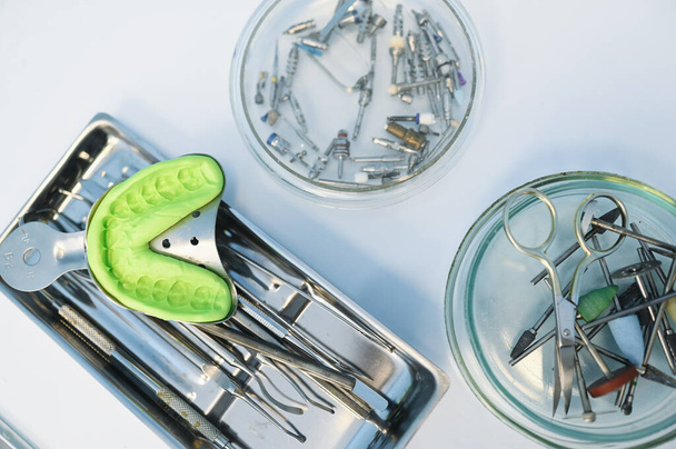 Verschiedene professionelle zahnärztliche Geräte, Instrumente und Werkzeuge in einer Zahnarztpraxis auf weißem Hintergrund. Silikonabguß des Kiefers - Foto, Bild
