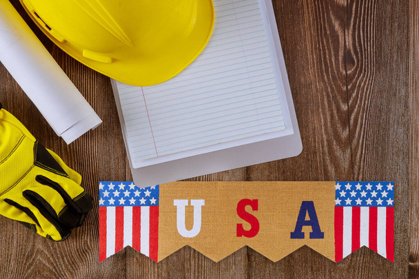 İşçi Bayramı 'nda ofis masasında boş defterle çalışan mühendis inşaat koruyucu sarı güvenlik kaskı Amerika Birleşik Devletleri' nin federal bayramıdır. - Fotoğraf, Görsel