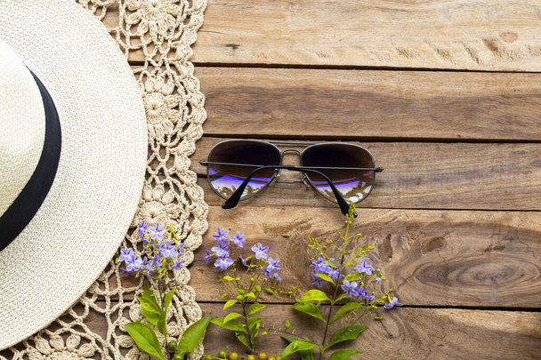 óculos de sol, crohet e chapéu de estilo de vida mulher relaxar verão com flores roxas arranjo flat lay estilo no fundo de madeira
 - Foto, Imagem