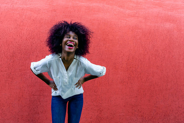 el Afroamericano Feliz contra la pared roja - Foto, Imagen