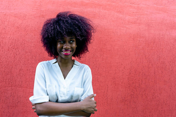 Szczęśliwy Afroamerykanin pod czerwoną ścianą - Zdjęcie, obraz