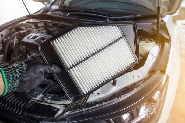 Nuevo filtro de aire del coche en las manos de los técnicos para reemplazar el viejo filtro de aire - Foto, imagen