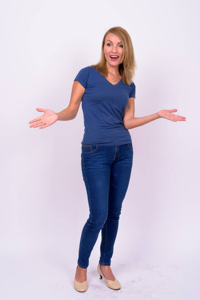 Studio shot of beautiful businesswoman with blond hair wearing blue shirt against white background - 写真・画像