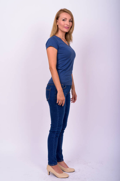 Studio shot of beautiful businesswoman with blond hair wearing blue shirt against white background - Foto, imagen