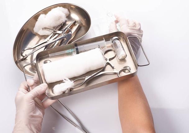 Стоматологические приборы в стерильной упаковке. Стоматологи сдают перчатки - Фото, изображение
