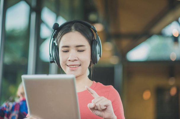 Ασιάτισσες γυναίκες που χρησιμοποιούν tablet ακούγοντας μουσική συνεδρίαση cafe, έννοια άνθρωποι επιχειρηματική τεχνολογία lifestyle - Φωτογραφία, εικόνα