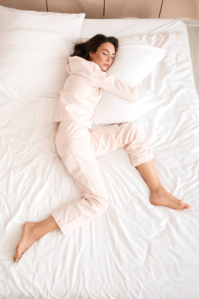 Νεαρή γυναίκα κοιμάται στο κρεβάτι, με θέα στην κορυφή - Φωτογραφία, εικόνα