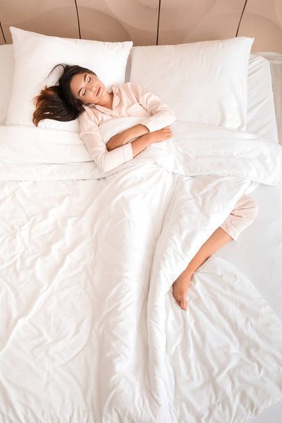 Νεαρή γυναίκα κοιμάται στο κρεβάτι, με θέα στην κορυφή - Φωτογραφία, εικόνα
