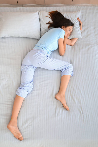Молода жінка спить у ліжку, вид зверху
 - Фото, зображення