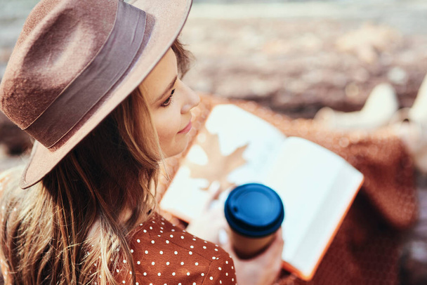 Vue grand angle de la femme avec café et livre en forêt - Photo, image