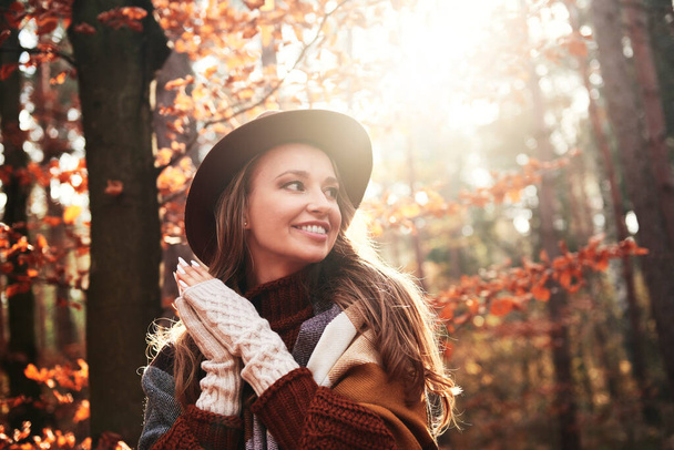 Χαμογελαστή νεαρή γυναίκα στο φθινοπωρινό δάσος - Φωτογραφία, εικόνα