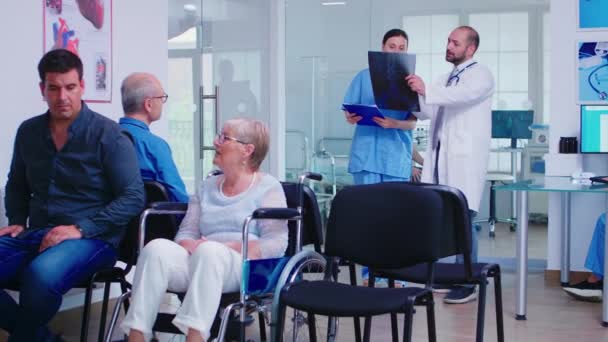 Verpleegster die radiografie bekijkt terwijl ze met de dokter praat - Video