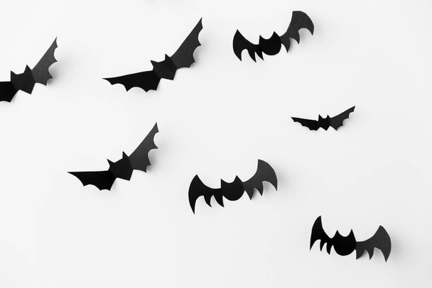 flock of black paper bats over white background - Foto, Imagem