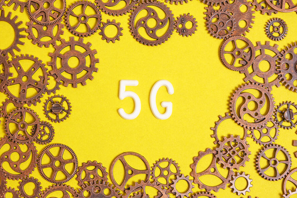 Modern communication technologies 5G logo on a yellow background among the gears - Foto, afbeelding