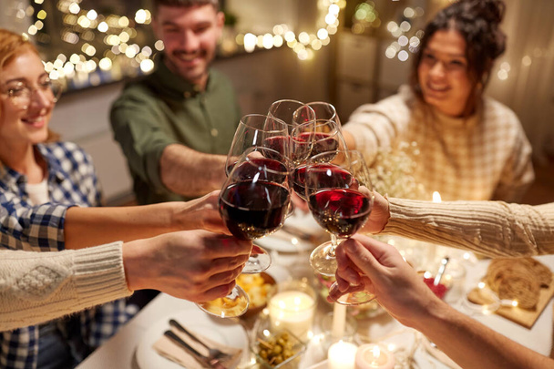 onnellisia ystäviä juo punaviiniä joulujuhlissa - Valokuva, kuva