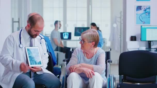 Arzt erklärt ältere Frau im Rollstuhl die Diagnose - Filmmaterial, Video