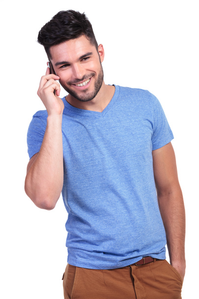 усміхнений молодий чоловік розмовляє по телефону
 - Фото, зображення