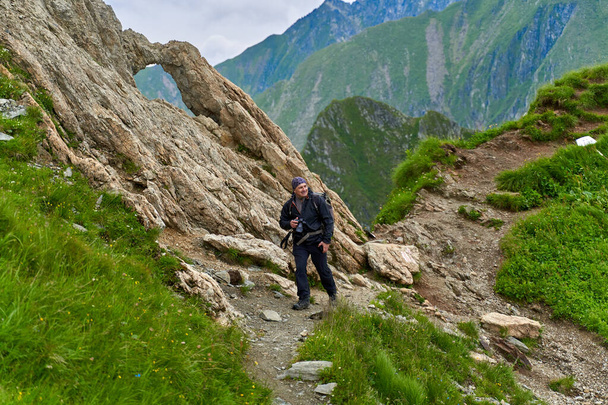 Professional nature photographer with camera and big backpack hiking into the highlands - Valokuva, kuva