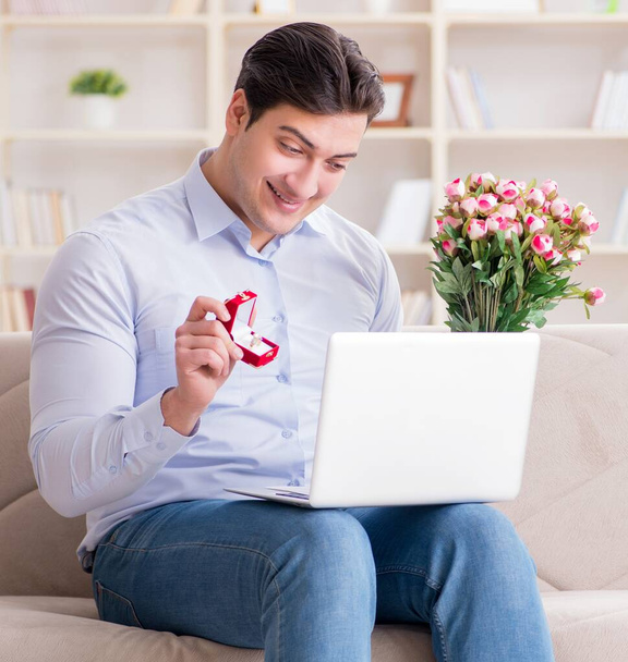 Der junge Mann macht per Internet-Laptop einen Heiratsantrag - Foto, Bild