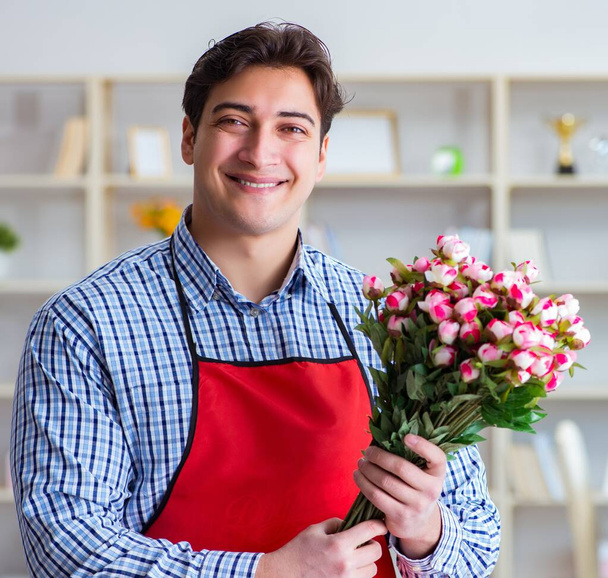 Asistente de floristería ofreciendo un ramo de flores - Foto, Imagen