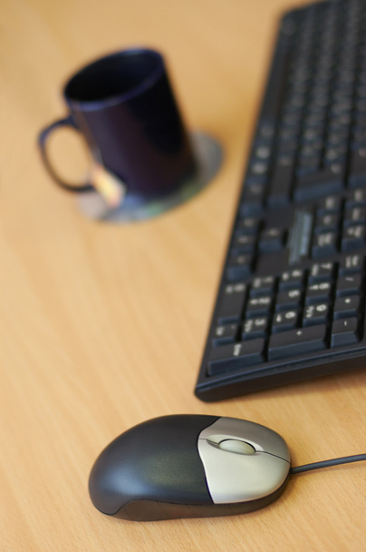 Computador mouse, teclado e xícara na mesa de madeira
 - Foto, Imagem