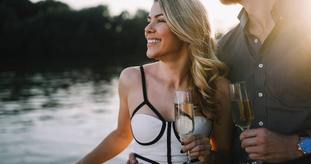 Happy young couple have a date and drinking champagne a on a boat - Fotografie, Obrázek