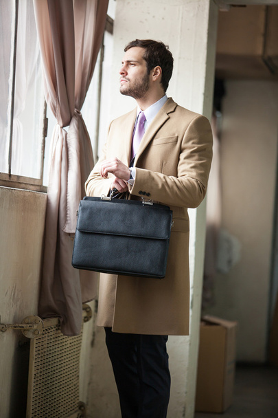 Young and handsome businessman looking out of the window - 写真・画像