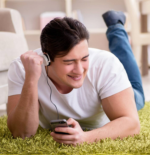Jongeman student die thuis naar muziek luistert - Foto, afbeelding