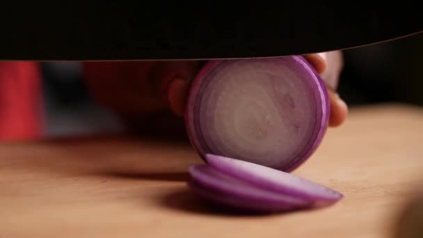 Hidasliikkeinen lähikuva liukuva tai kuorma laukaus sipuli on pilkottu musta kokki veitsi leikkuulauta - Materiaali, video