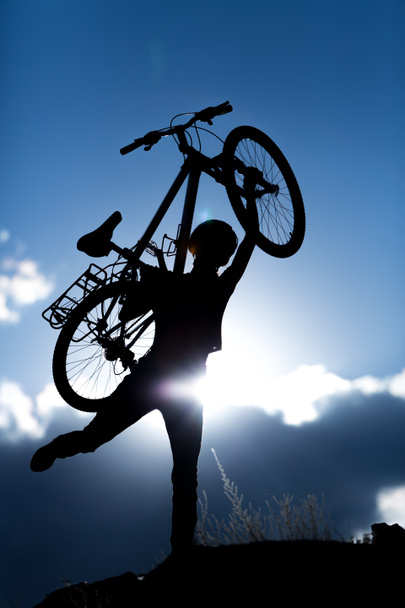 Woman with bike over sunset - Photo, Image