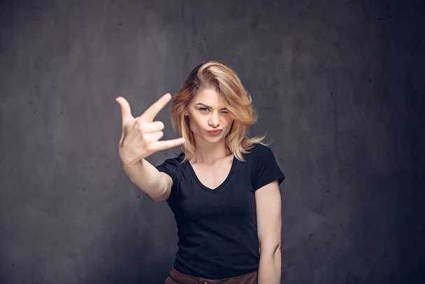 Молодая белая женщина показывает рок-жест - Фото, изображение