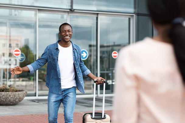 Ευτυχισμένος μαύρος άντρας συναντά την κοπέλα του μετά την προσγείωση στο αεροδρόμιο - Φωτογραφία, εικόνα