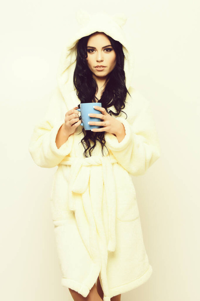 fille sexy posant en peignoir de velours beige avec tasse - Photo, image