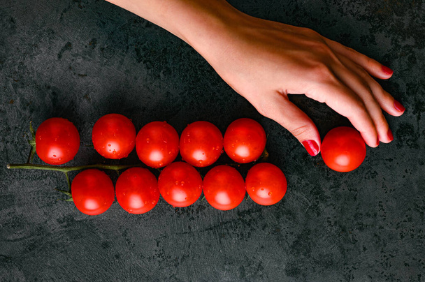 czerwone pomidory i ręce, na marmurze widok z góry. Wysokiej jakości zdjęcie - Zdjęcie, obraz
