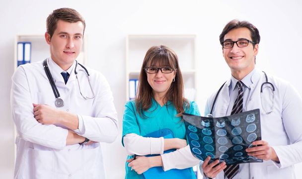 Drei Ärzte diskutieren Scanergebnisse von Röntgenbild - Foto, Bild