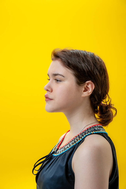 Close up fashion portrait beautiful young brunette woman on yellow background. Copy space. - Foto, afbeelding