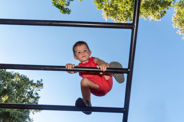 A kisfiú magas akadályokba ütközik a játszótéren. - Fotó, kép