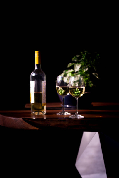 Witte wijn geserveerd op een luxe houten tafel - Foto, afbeelding