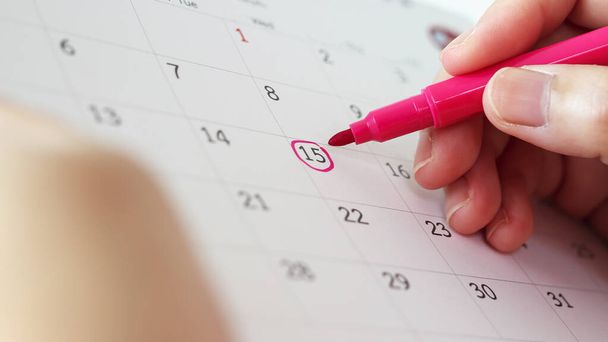 Рука с ручкой на 15-й день календарного дня - Фото, изображение