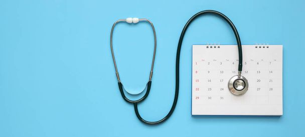 Stetoscopio con calendario pagina data su sfondo blu medico appuntamento concetto medico - Foto, immagini